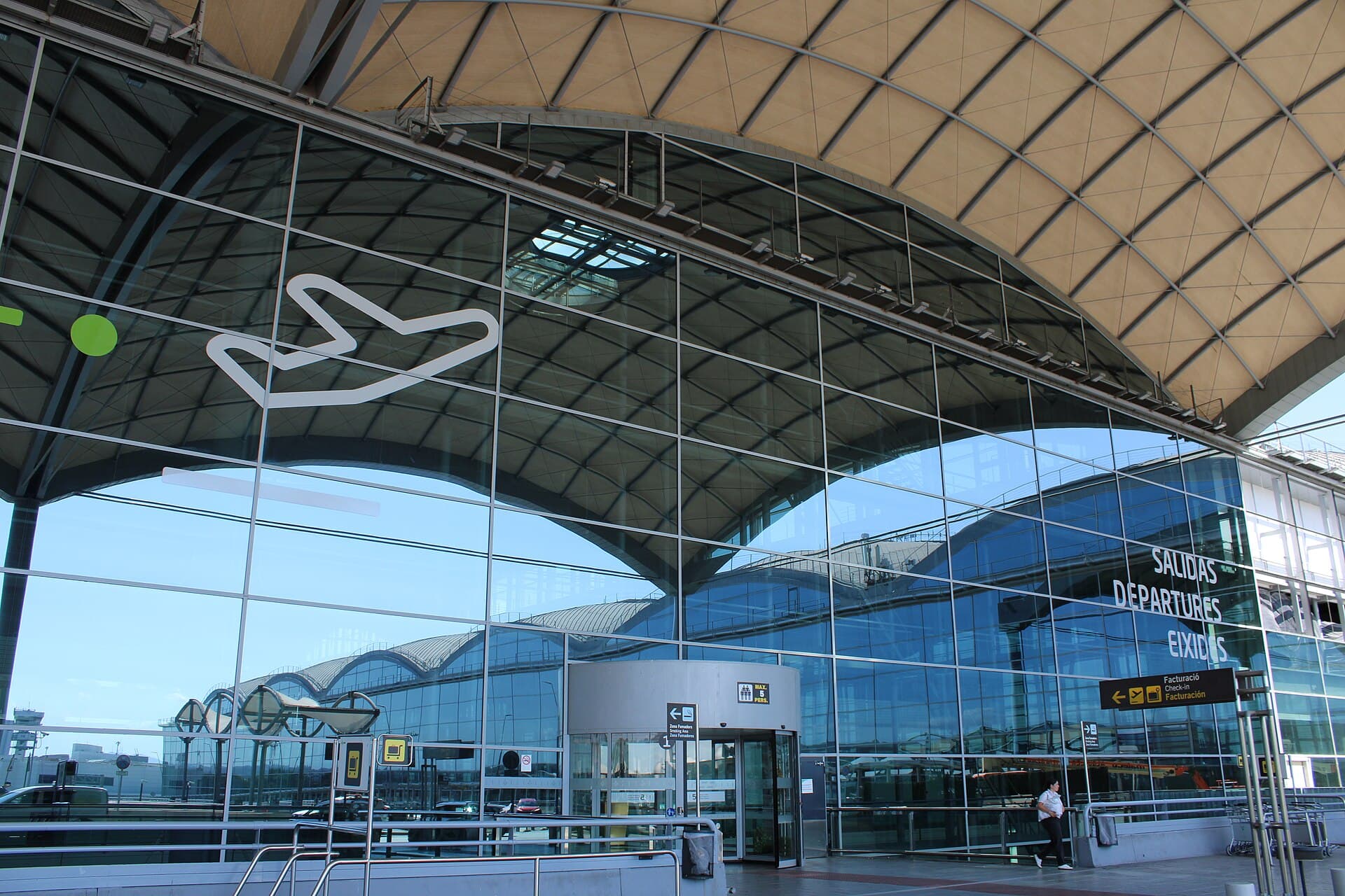 The glass front of the departures hall at Alicante-Elche Airport, under its curved roof