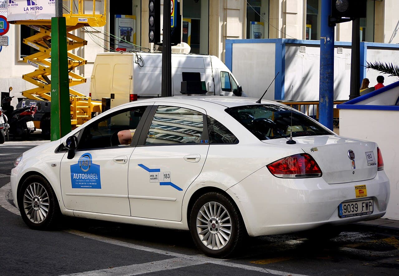 A white taxi on a street in Alicante