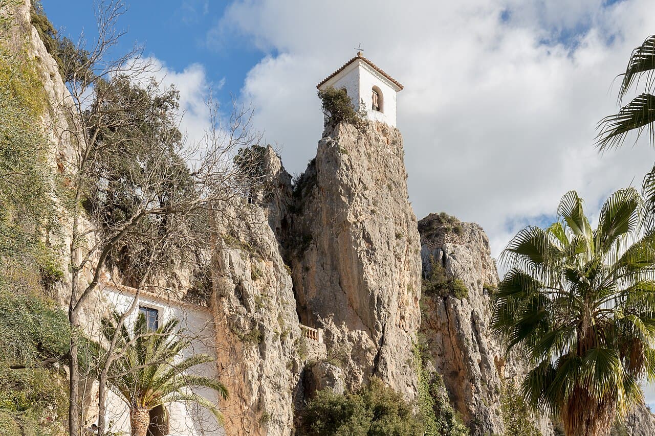 The white bell tower of Guadalest perched on a limestone crag