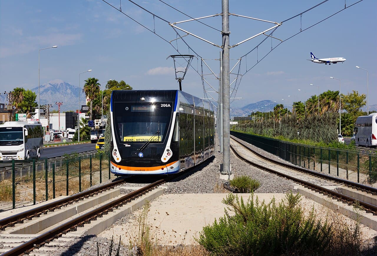An AntRay tram at Sinan station, with a plane coming in to land