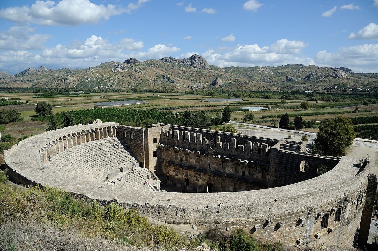 The Roman theatre of Aspendos seen from the hill above, with mountains behind