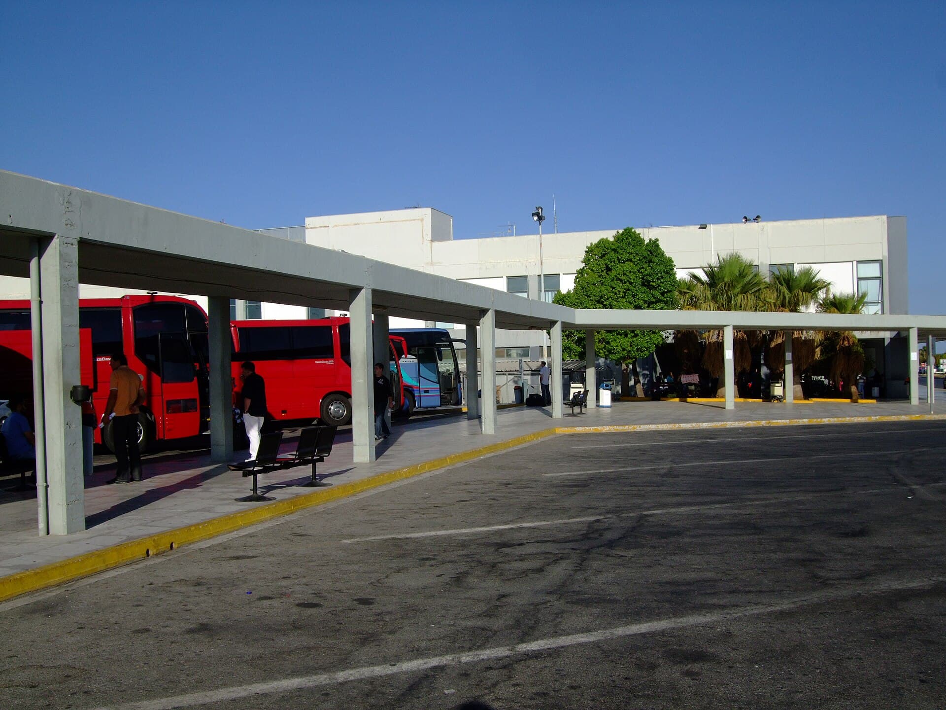 Coaches waiting beside the covered walkway outside the terminal at Chania Airport