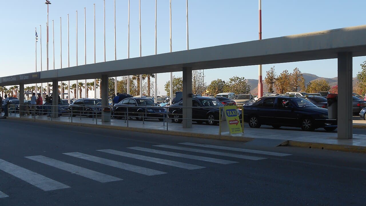 The covered taxi stand outside Chania Airport, with a taxi sign by the kerb
