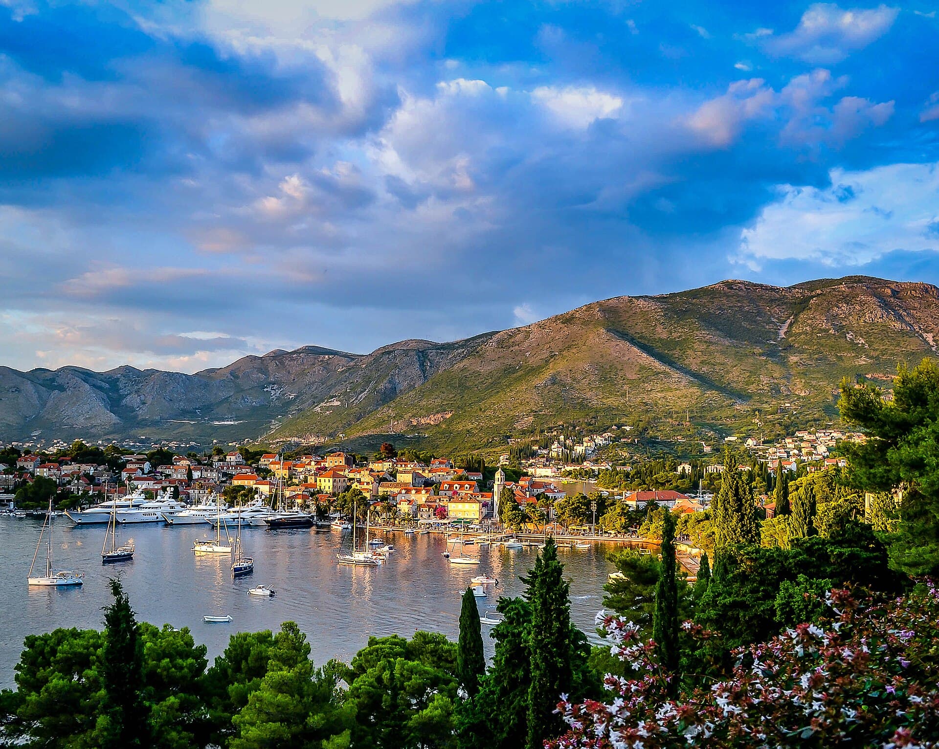 Boats moored in the harbour at Cavtat below green hills