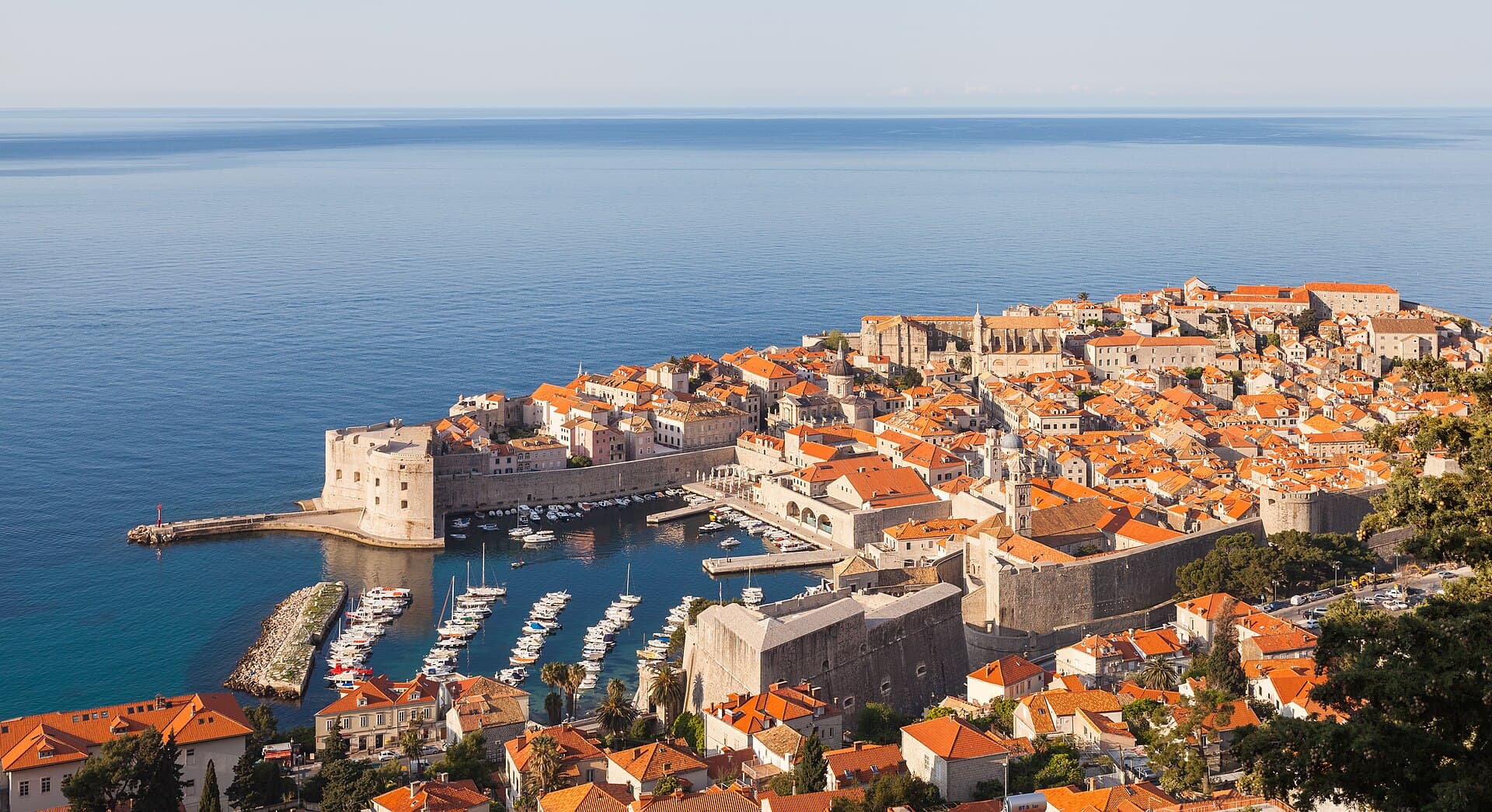 The walled Old Town of Dubrovnik and its harbour seen from the hillside above