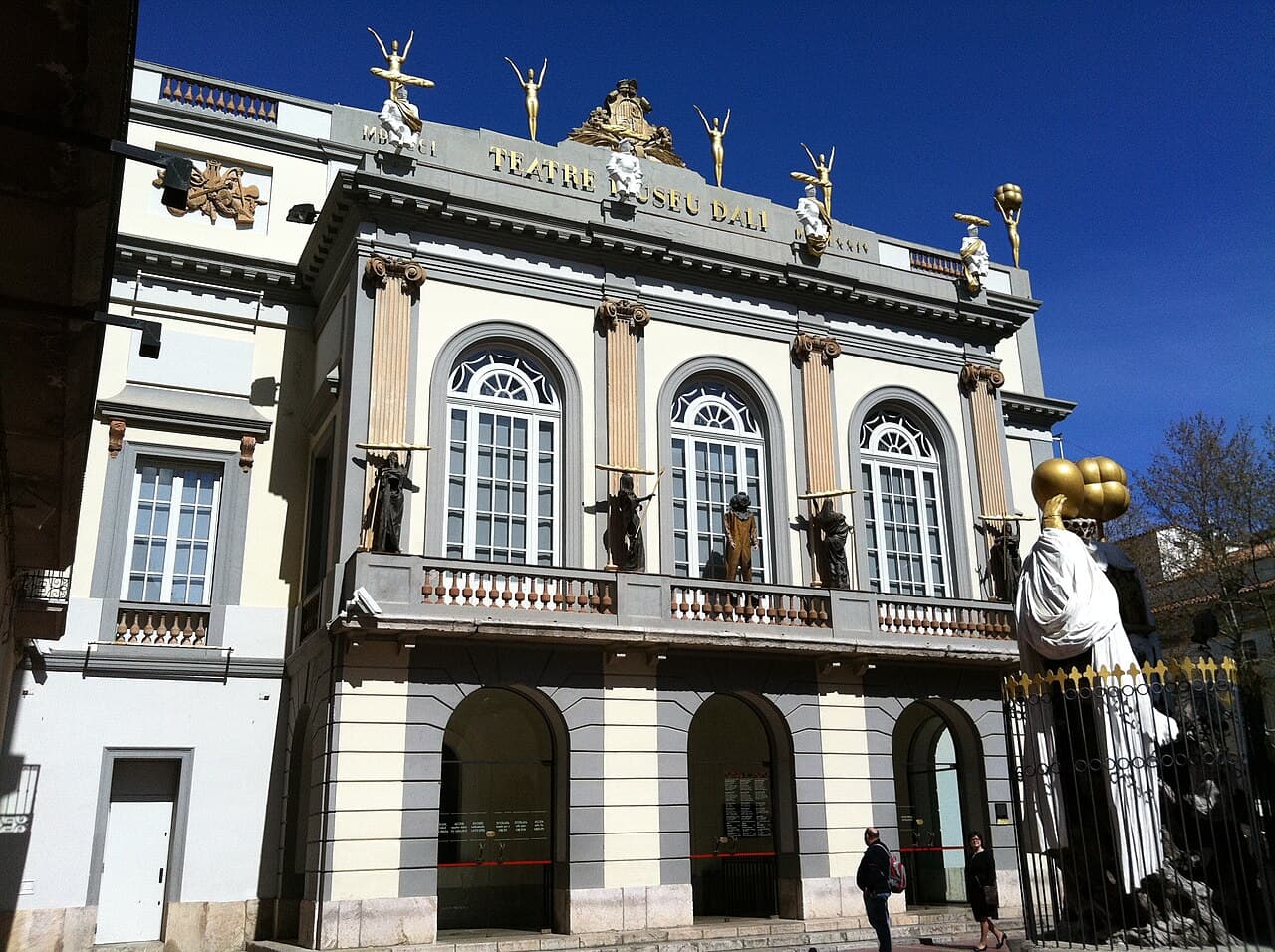 The façade of the Dalí Theatre and Museum in Figueres, topped with golden figures and eggs