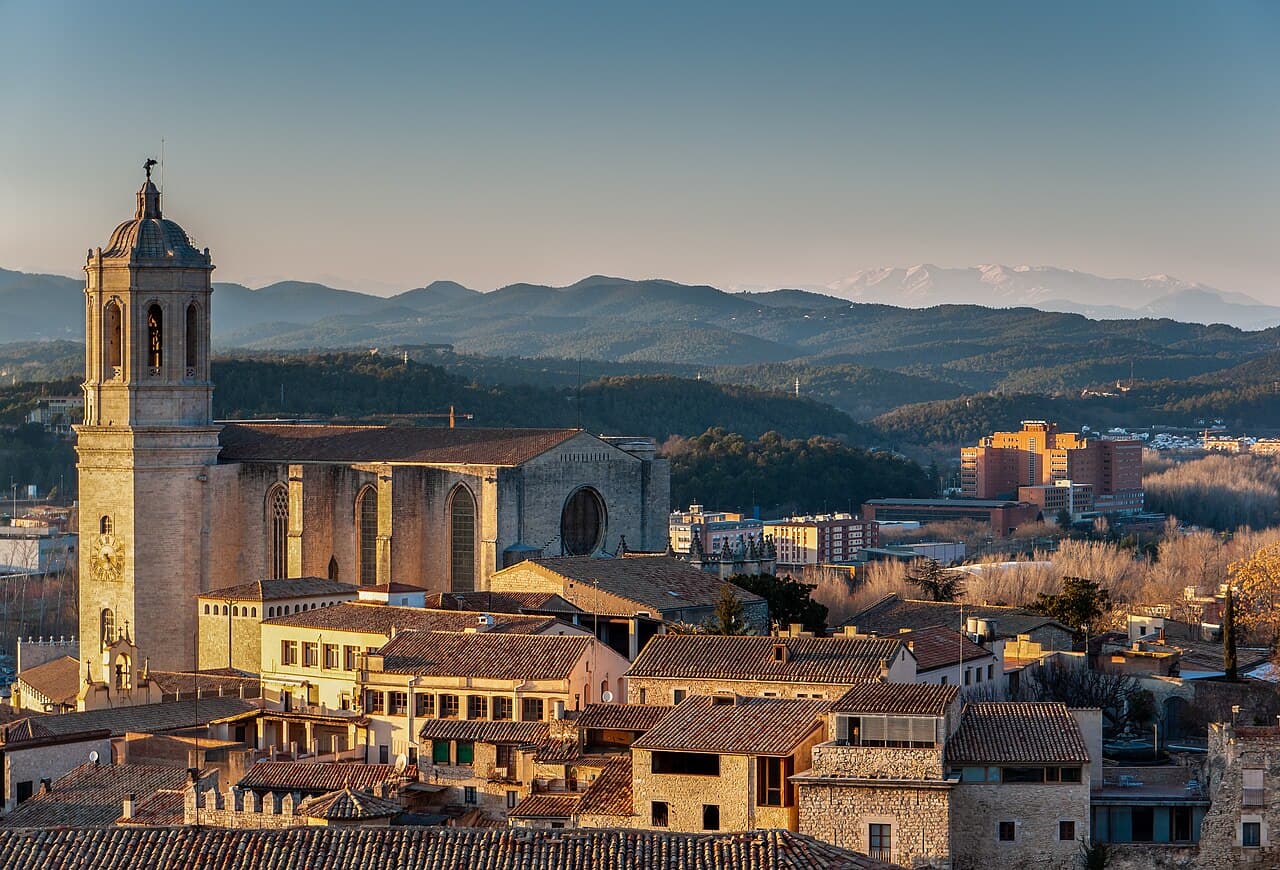 Girona Cathedral rising above the roofs of the old city, with mountains behind