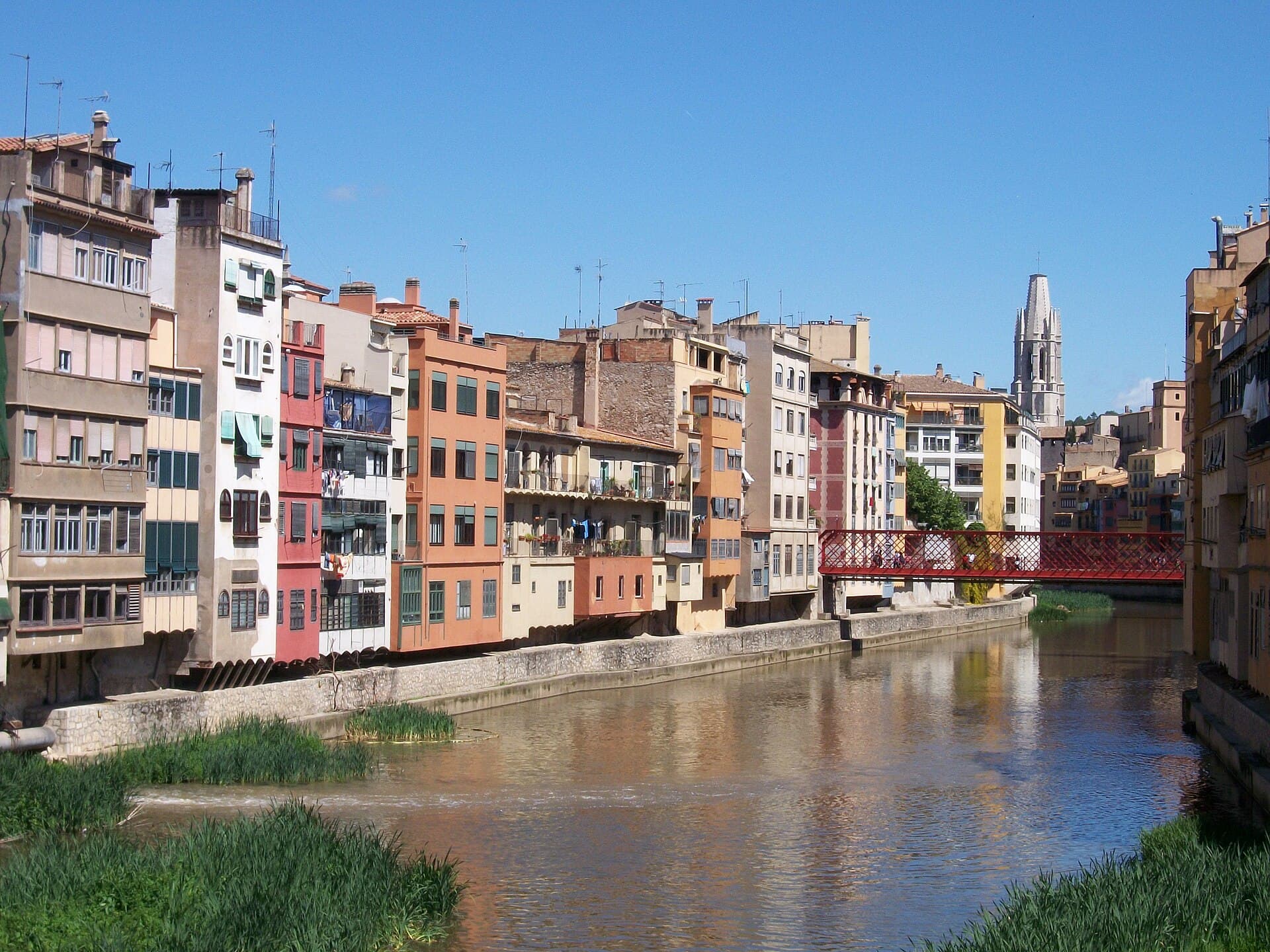 The painted riverfront houses of Girona above the Onyar, with the Pont Eiffel and the cathedral tower behind