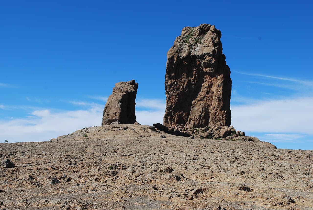 The tall rock column of Roque Nublo against a deep blue sky