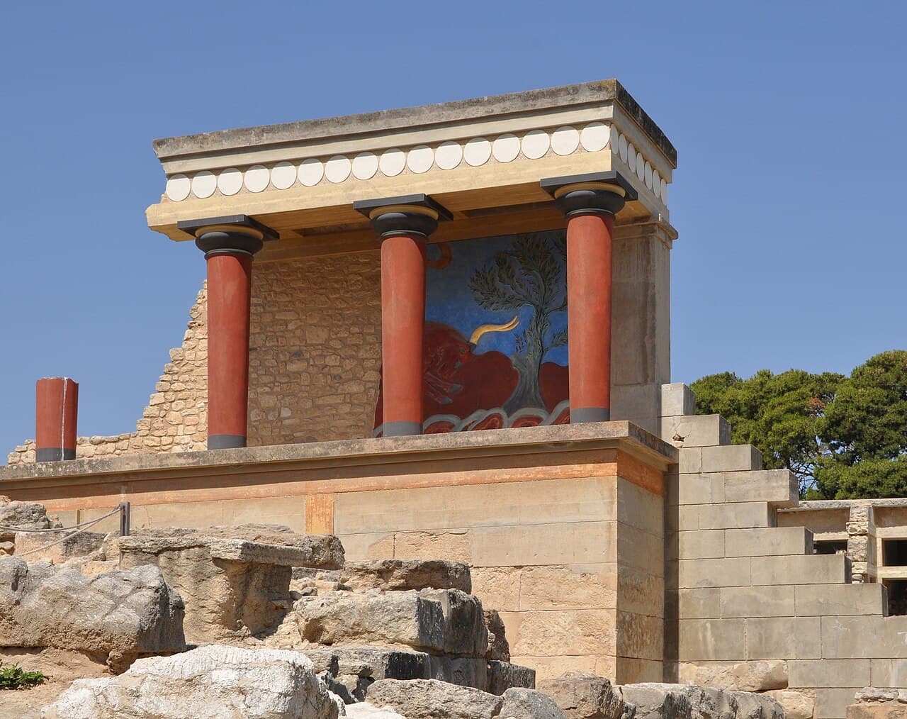 The reconstructed north entrance of the palace of Knossos, with red columns and a bull fresco
