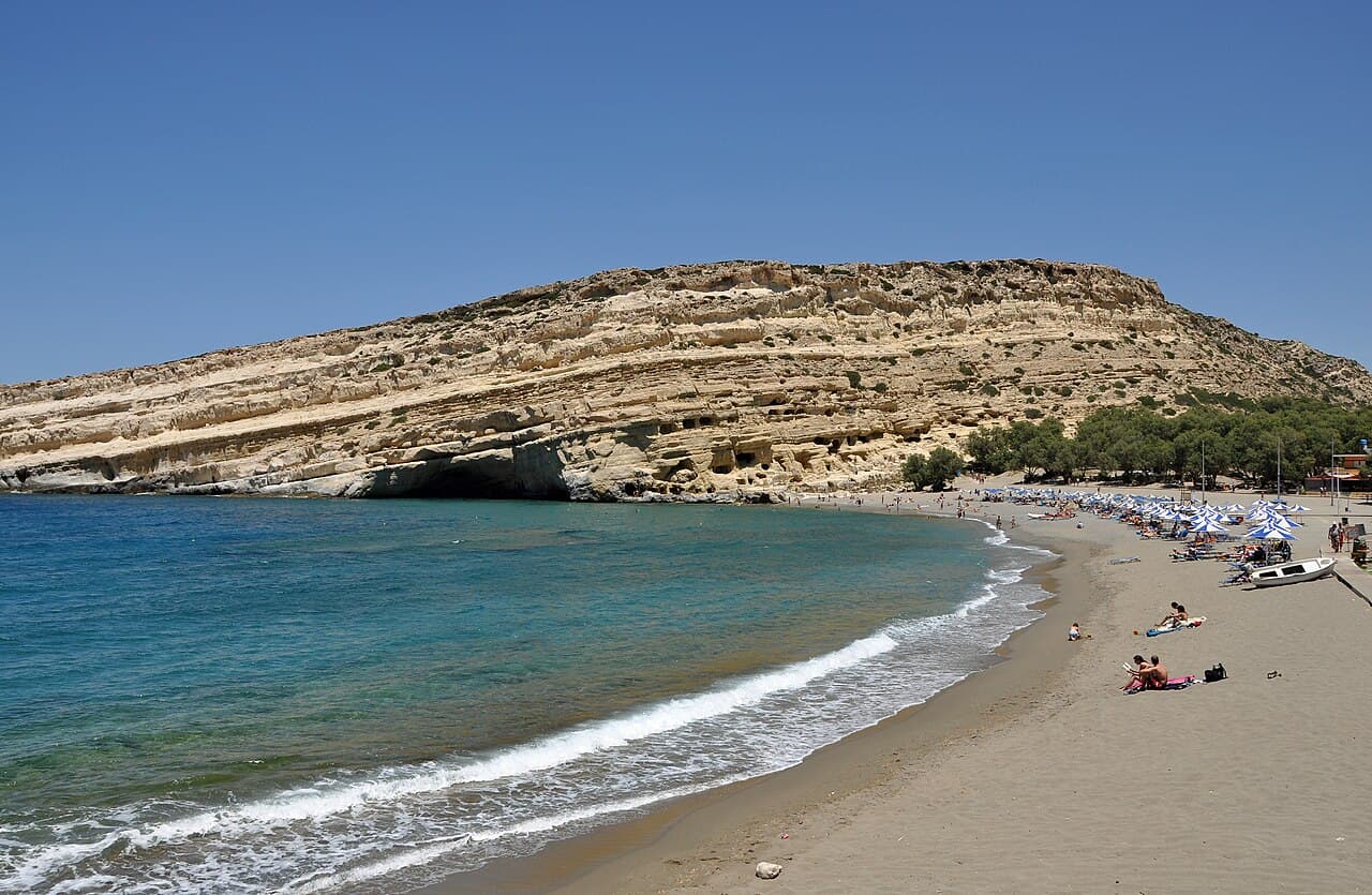 The curved beach at Matala beneath its sandstone cliffs