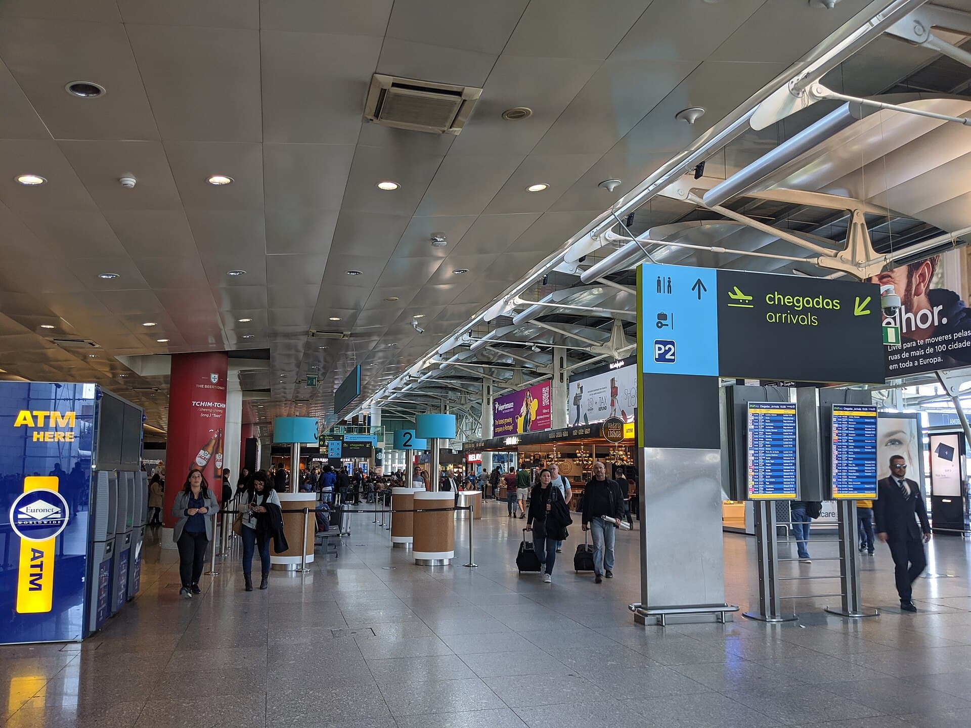 Travellers with luggage in the arrivals hall at Lisbon Airport