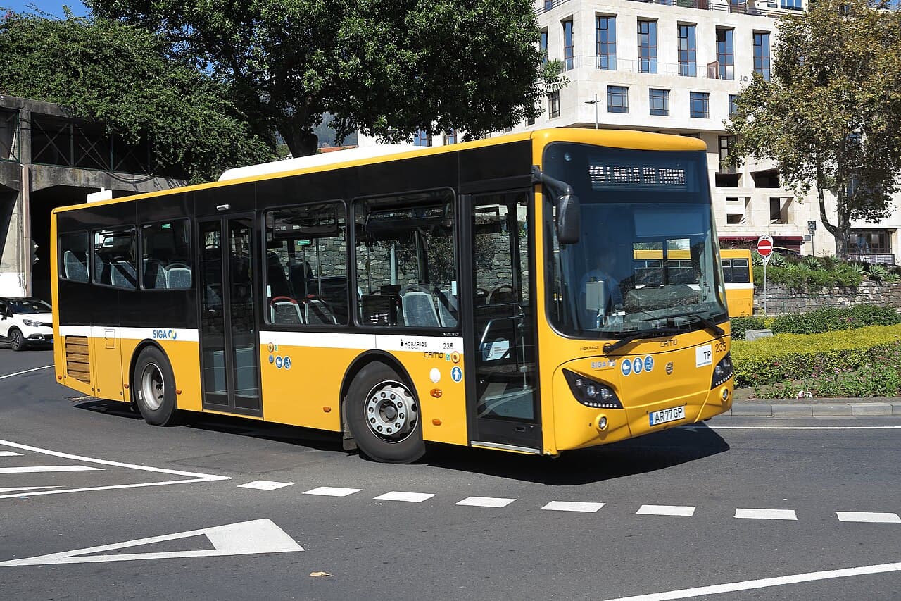 A yellow city bus on a street in Funchal