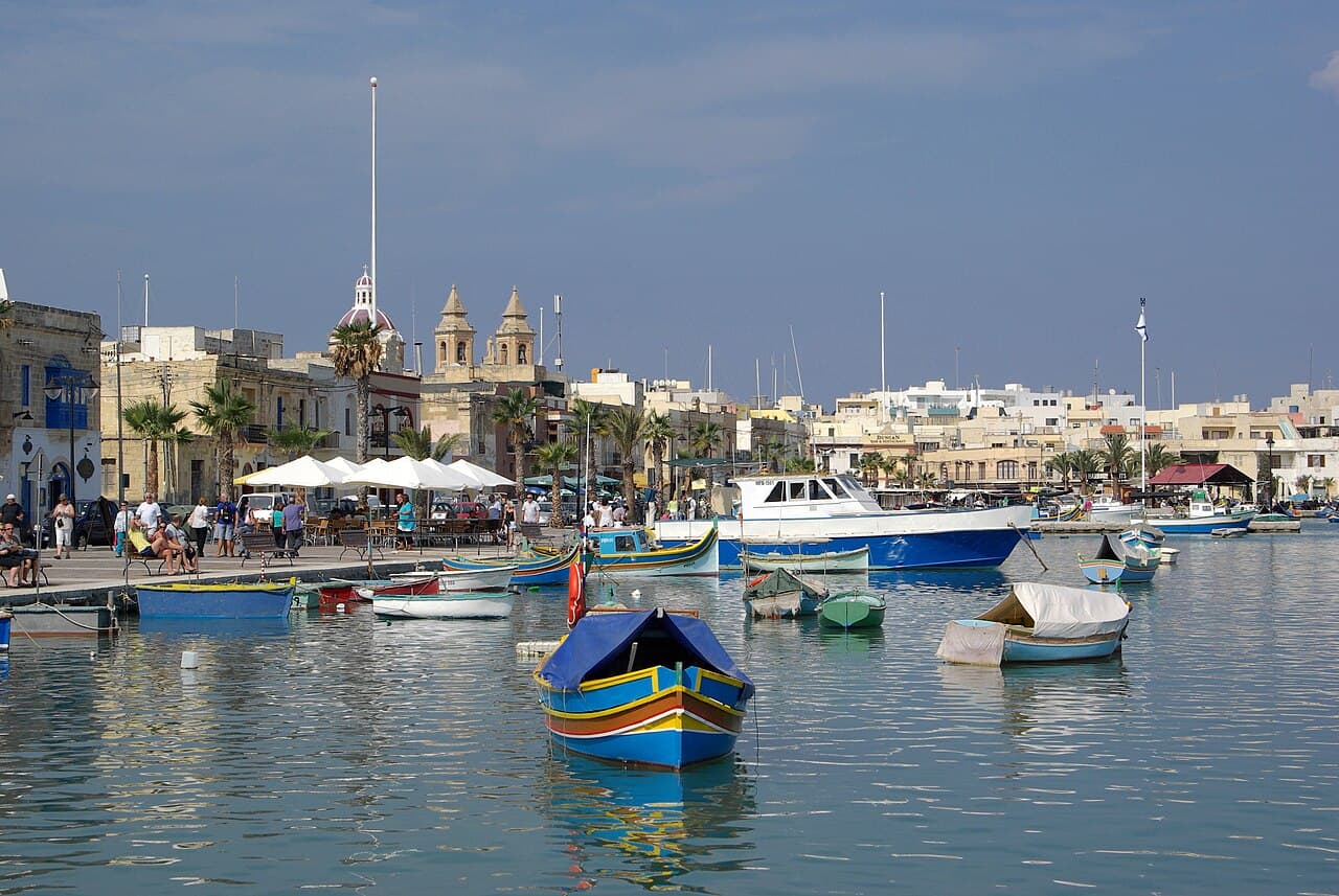 Painted luzzu fishing boats moored in the harbour at Marsaxlokk