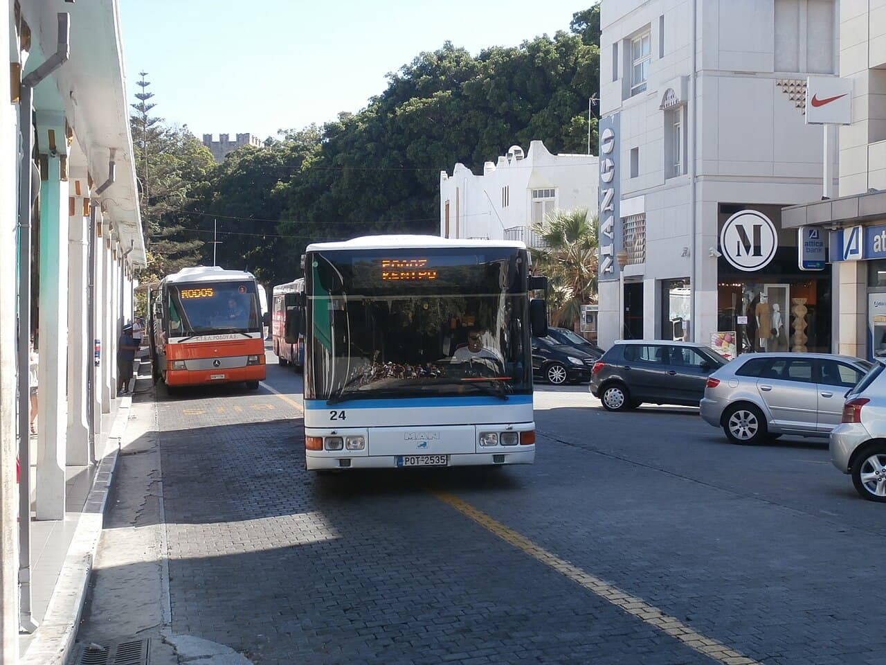 A RODA bus and an orange KTEL coach at a bus station in Rhodes Town
