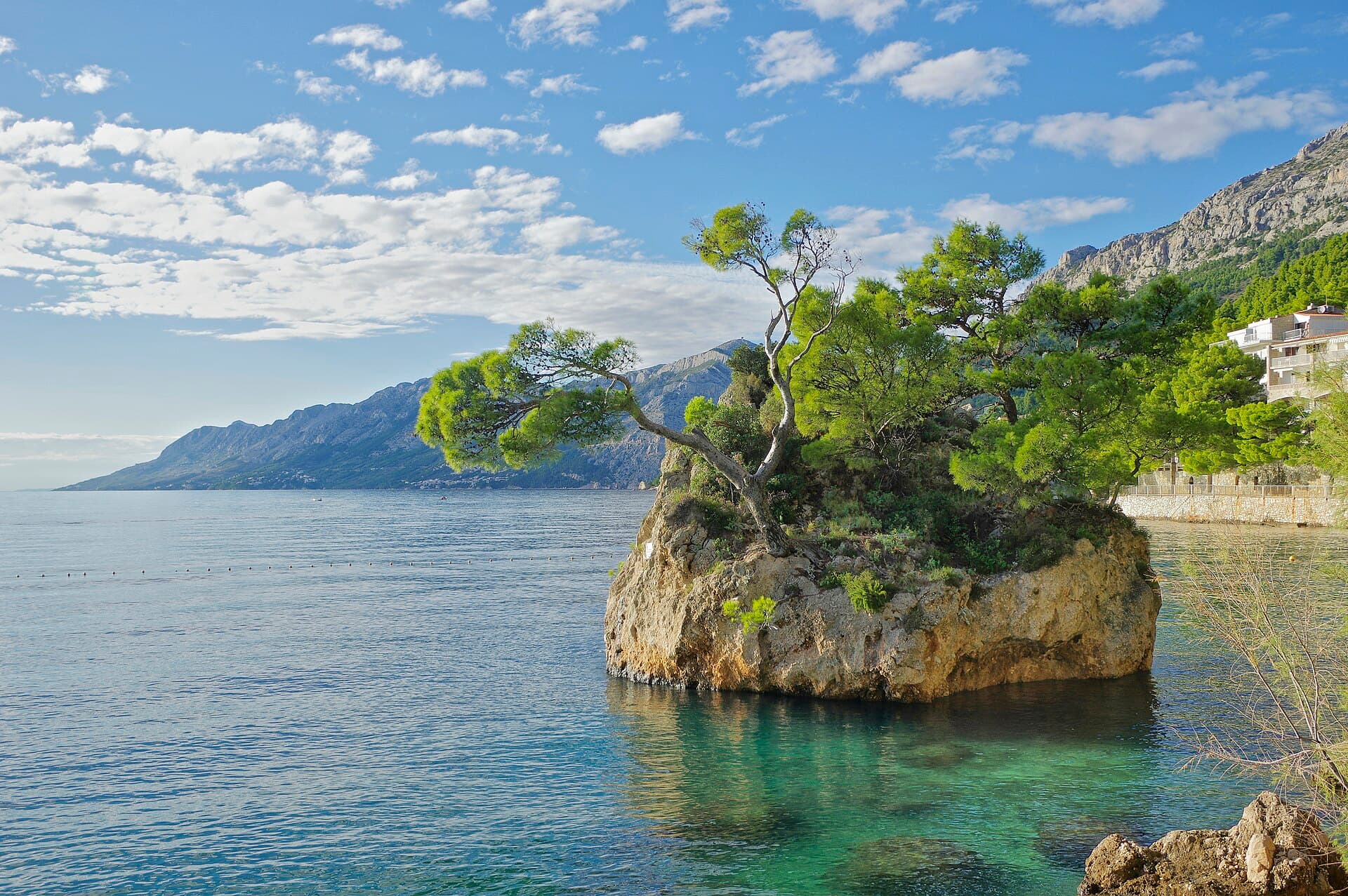 The pine-topped Brela Stone in the sea off the beach at Brela