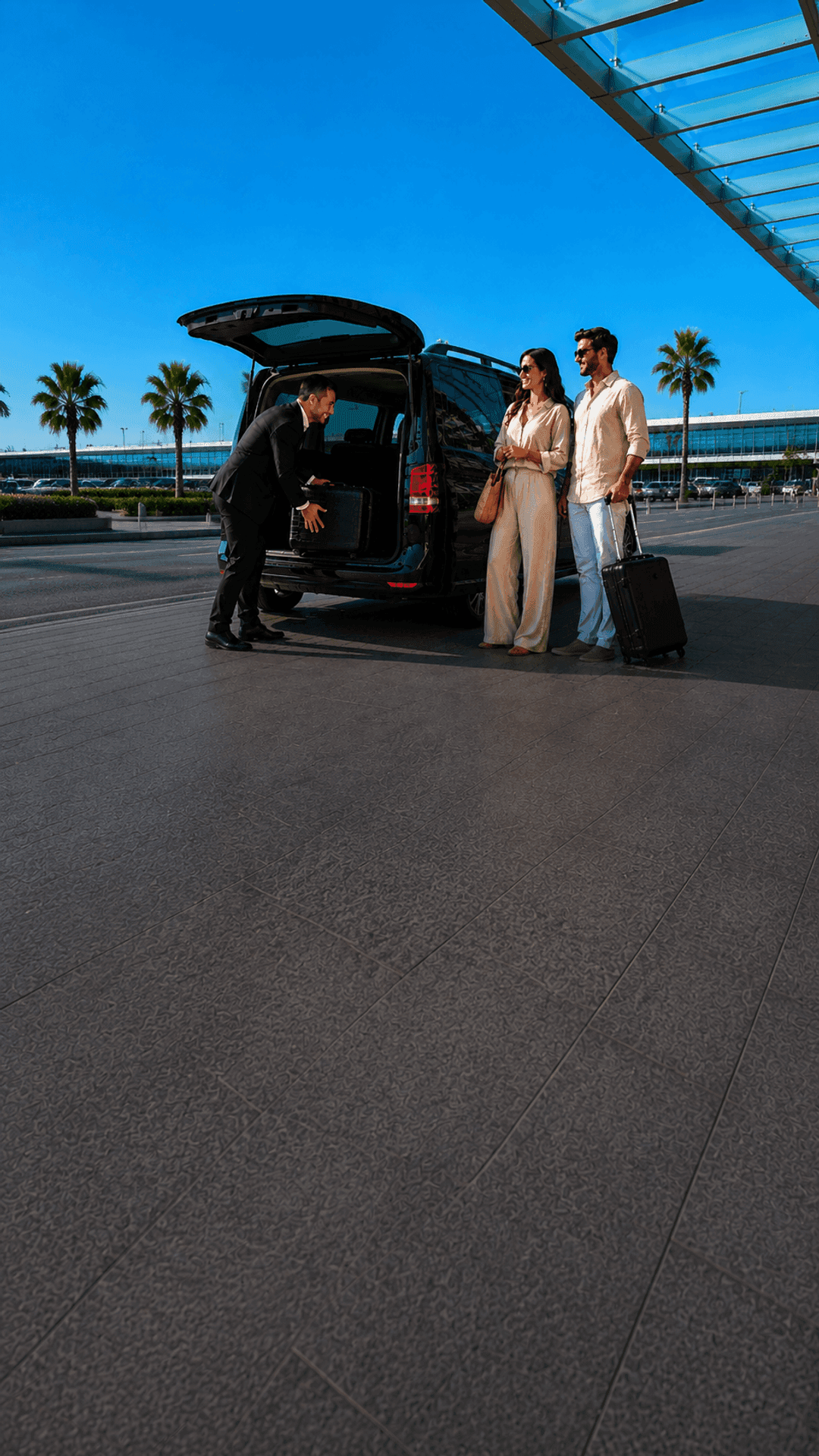 A chauffeur loading luggage into a HolidayCab van at the airport