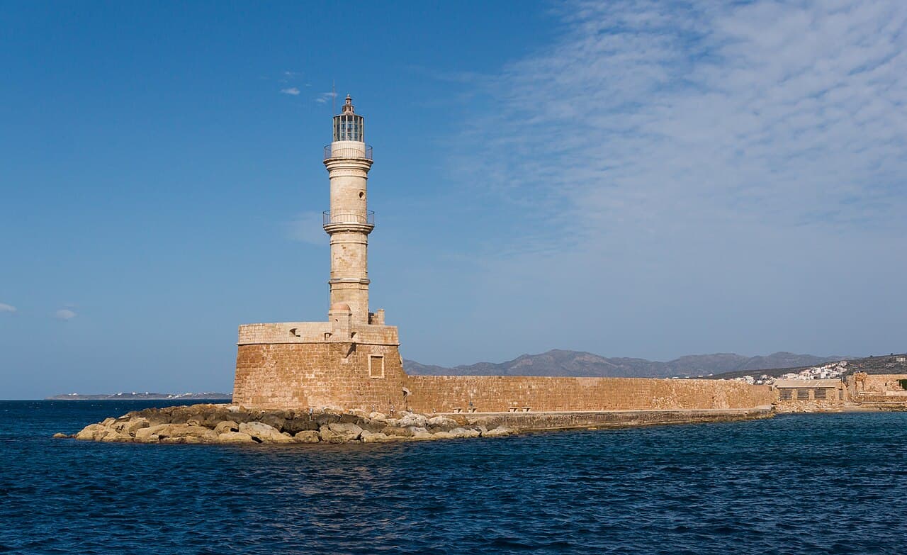 The stone lighthouse at the entrance to Chania’s old harbour under a blue sky