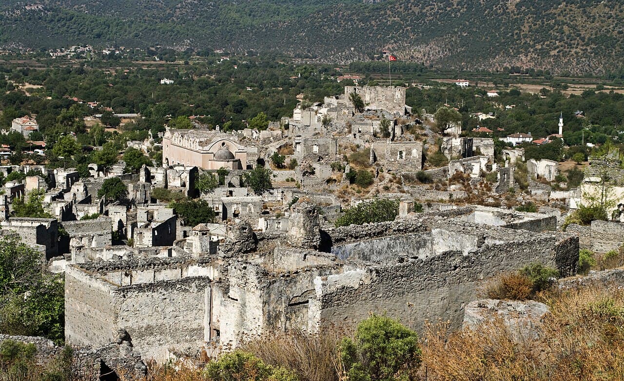 Roofless stone houses and a church in the abandoned village of Kayaköy on its hillside