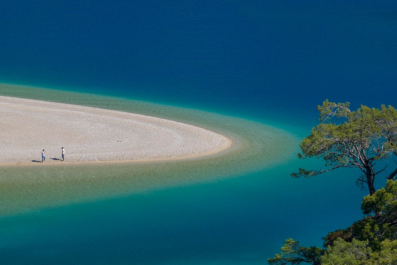 The tip of the beach spit at Ölüdeniz, surrounded by turquoise and deep blue water