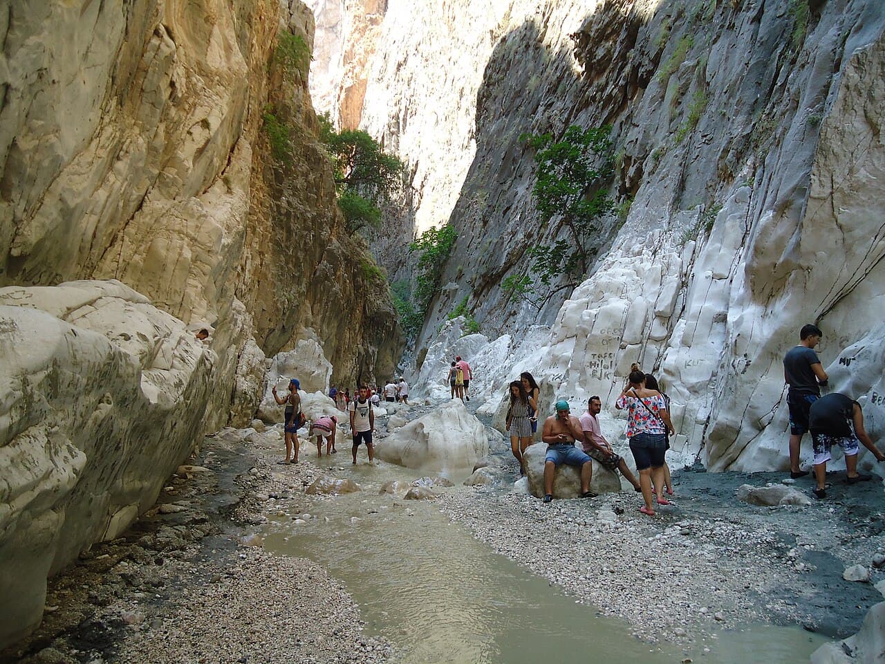 Visitors wading along the stream between the high rock walls of Saklıkent Gorge