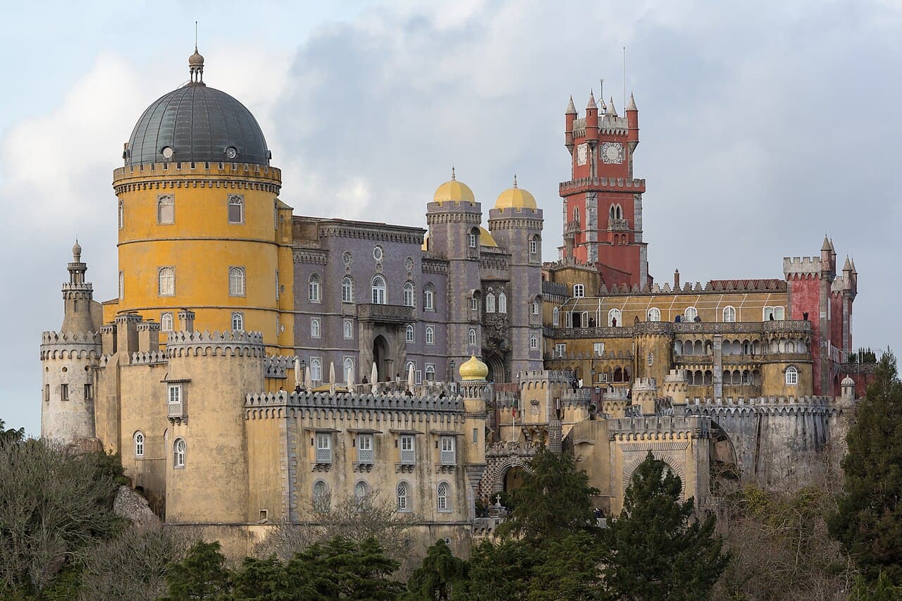 The red and yellow towers of Pena Palace above the woods of Sintra