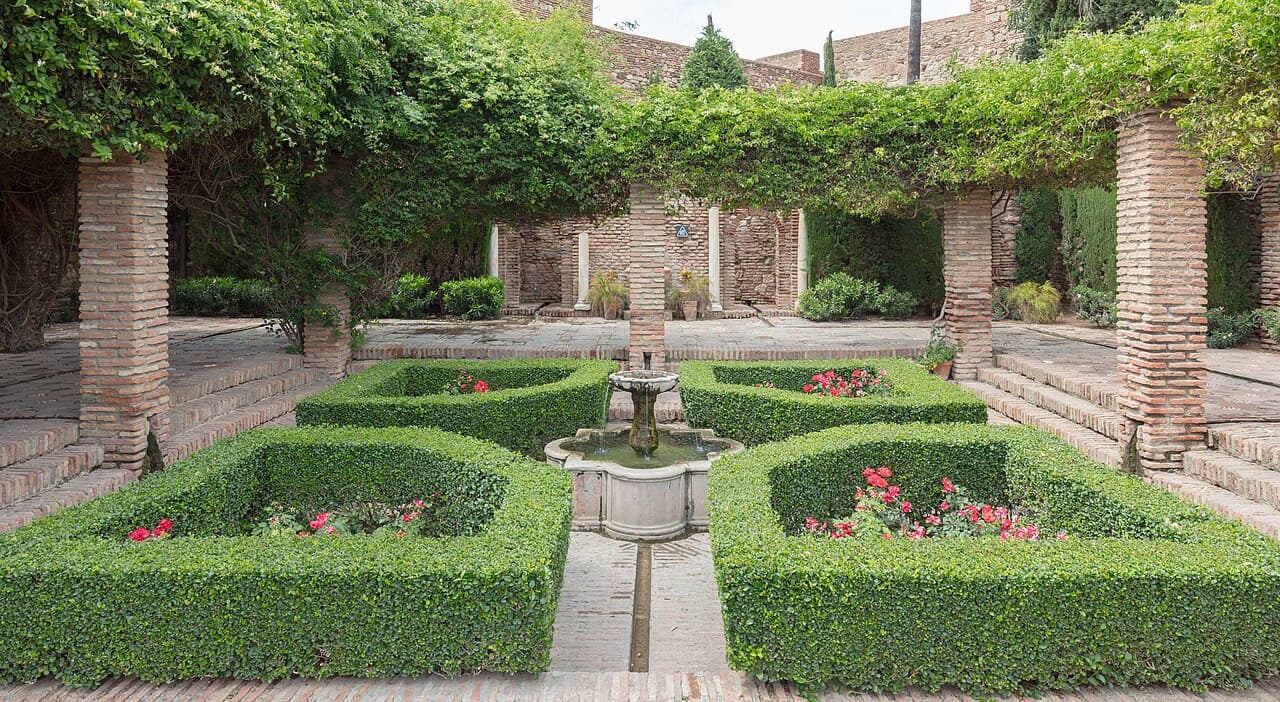 A hedged courtyard garden with a fountain inside the Alcazaba of Málaga