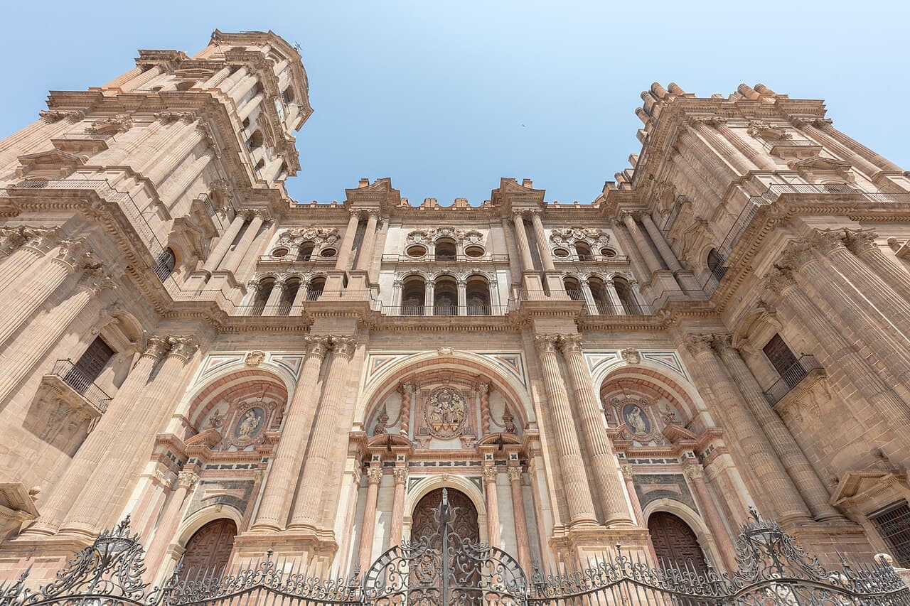 The Baroque façade of Málaga Cathedral under a blue sky