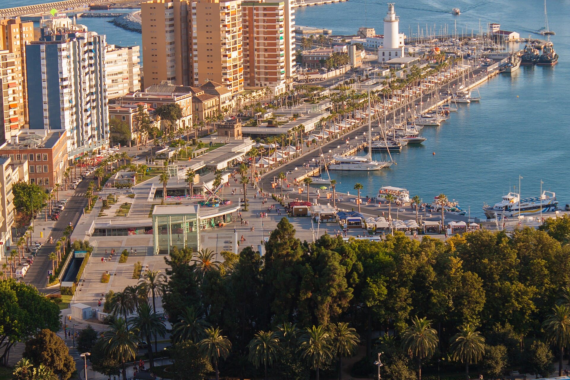 Málaga’s port, the palm-lined Muelle Uno promenade and the lighthouse, seen from above in evening light